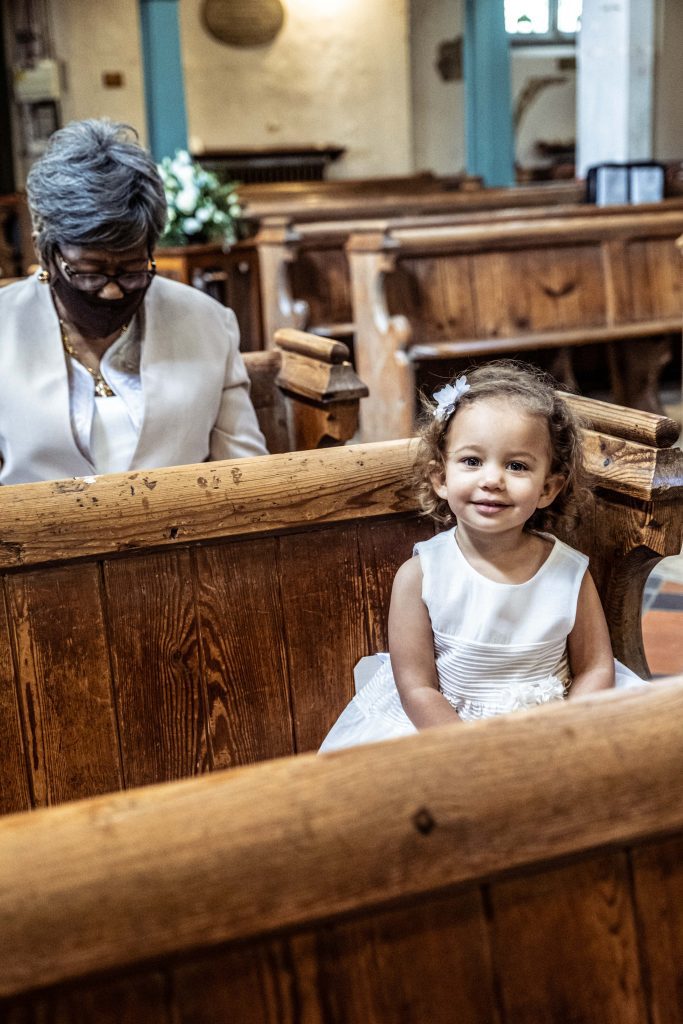 flower girl at london wedding sitting in church, wedding photographer