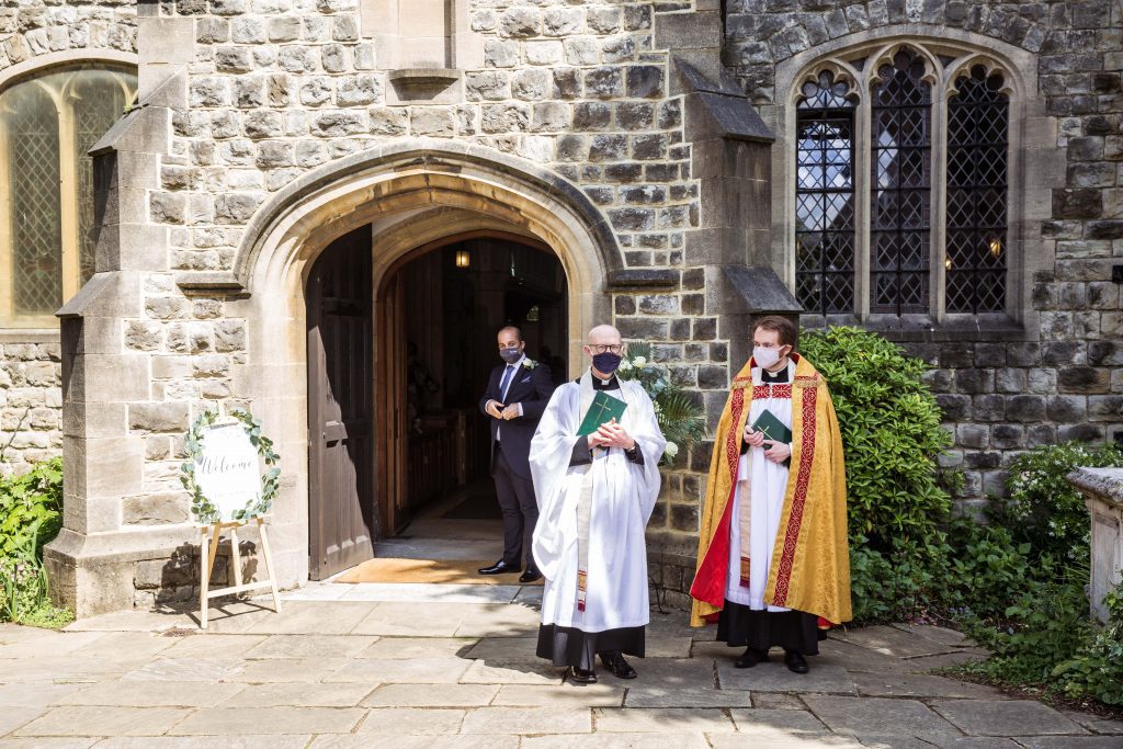 vicar outside london church waiting for bride