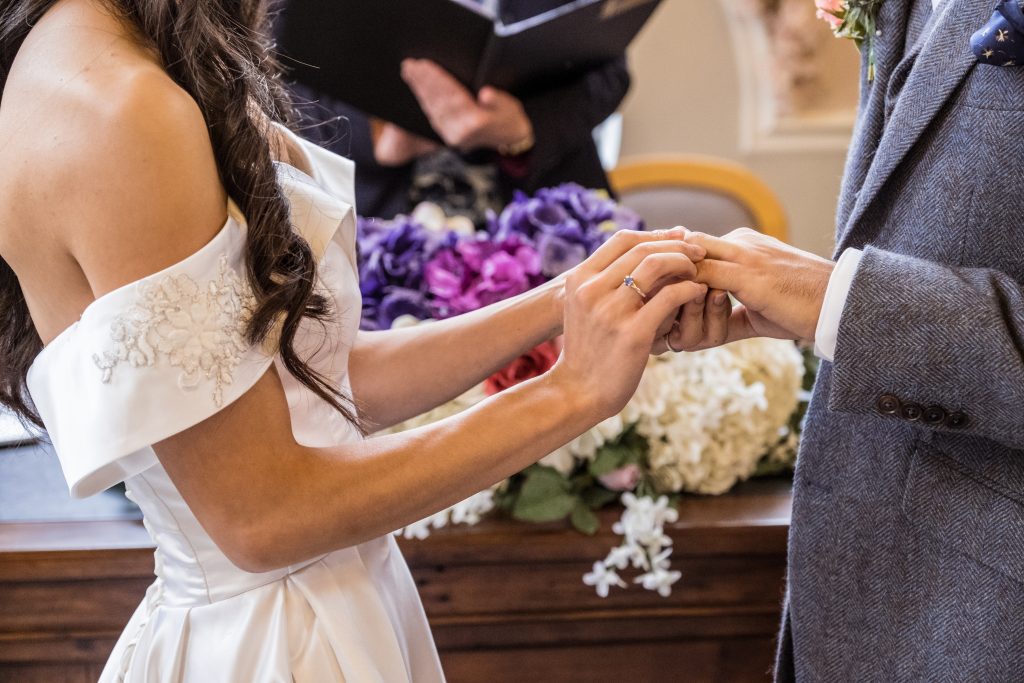 bride places ring on finger