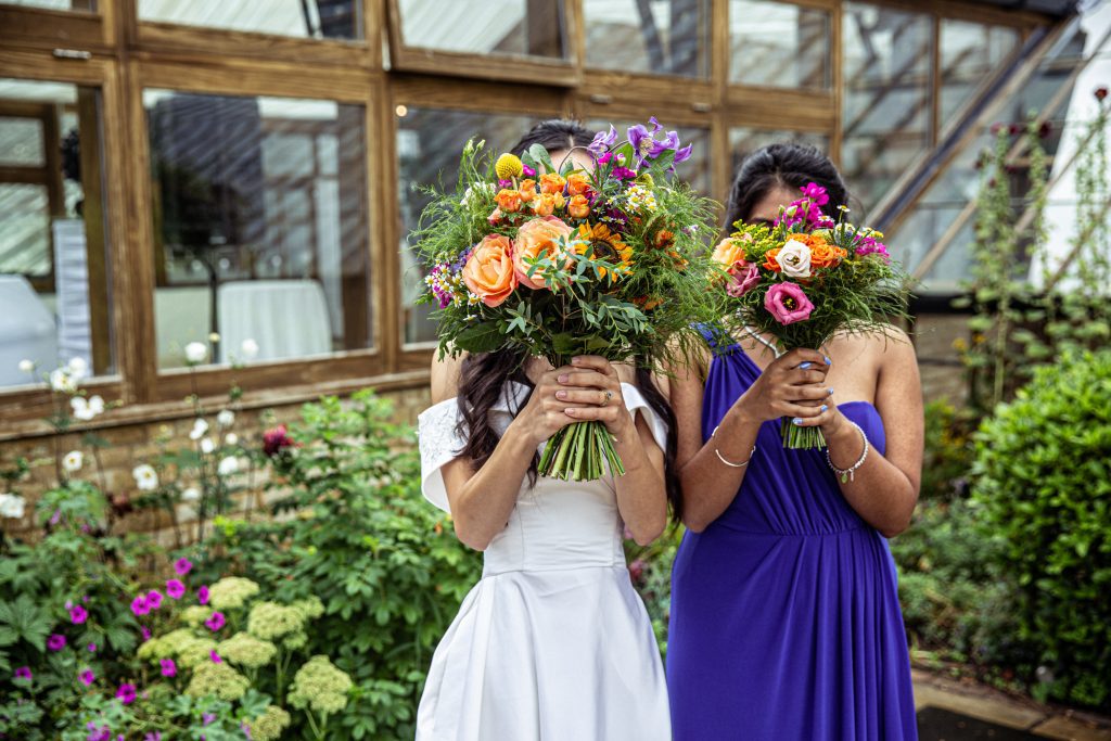 bride and maid of honour with flowers, Hanbury Manor photography
