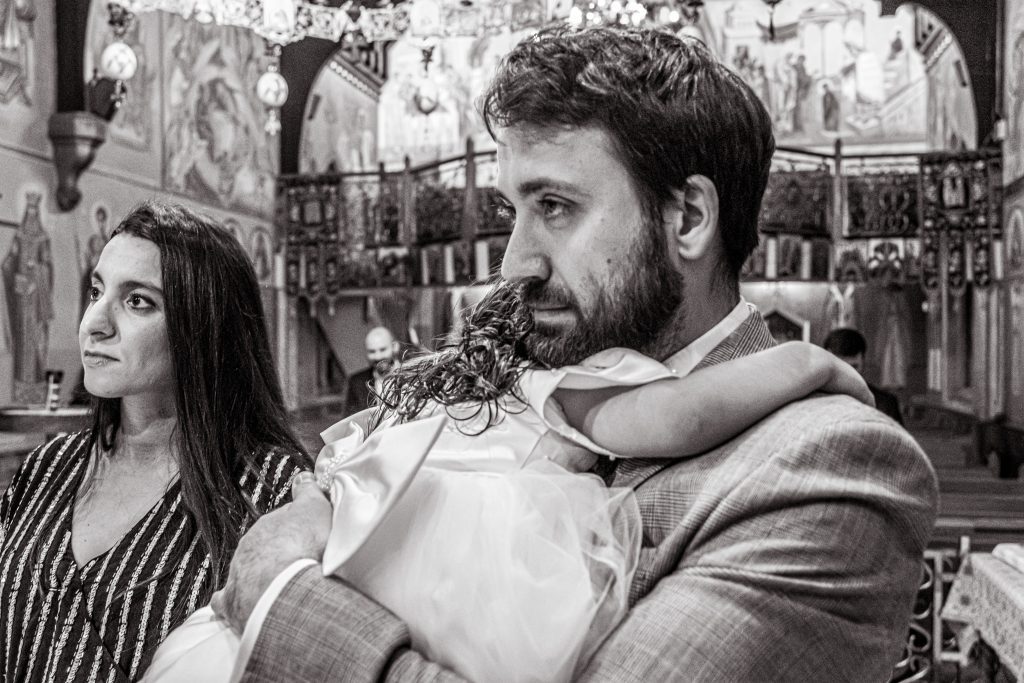 a father comforts daughter at greek christening twelve apostles