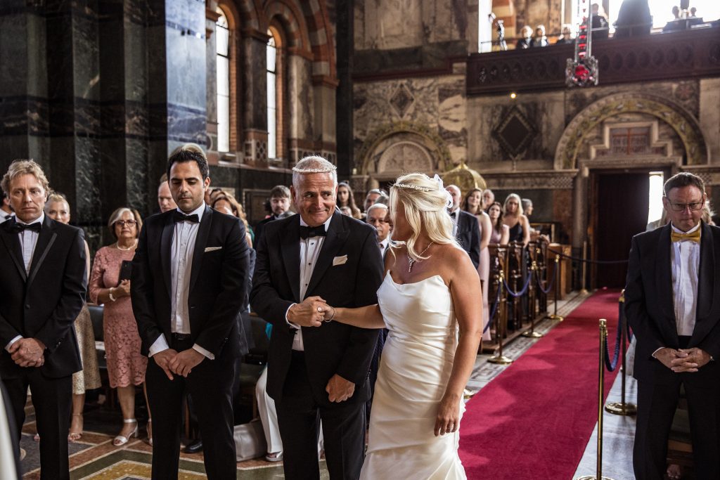 Groom looks at bride at St Sophia greek orthodox wedding in Moscow road London