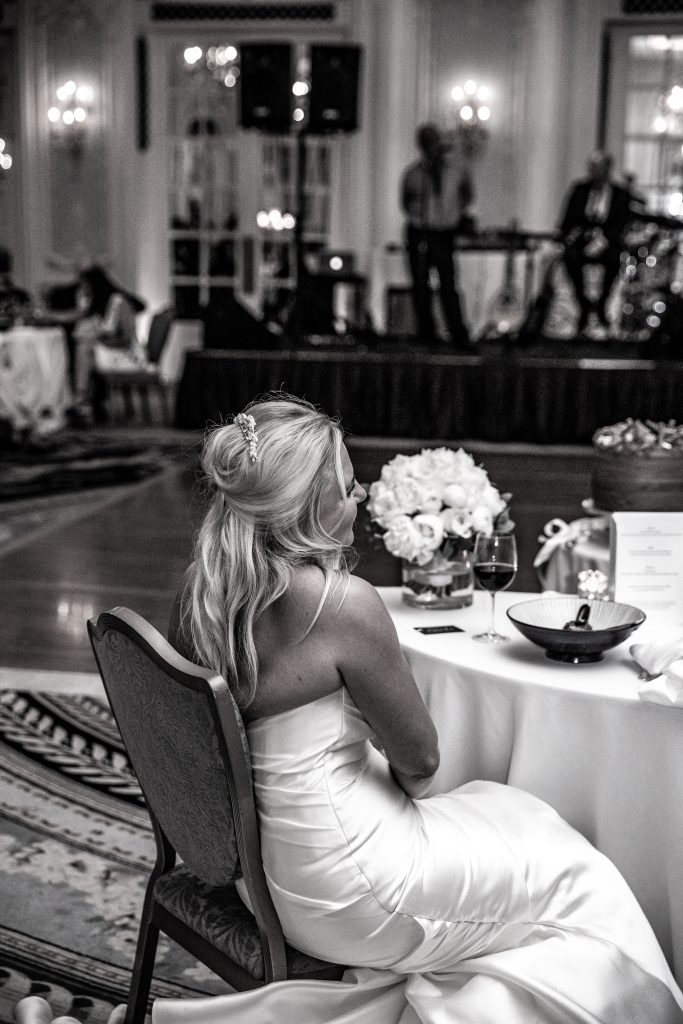 A bride watches the speeches at her wedding at her table at The savoy hotel