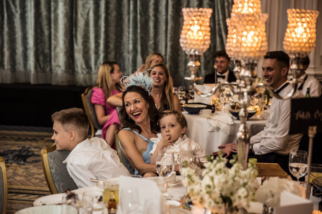 A happy guest listens to speeches at a wedding function at the Savoy in London