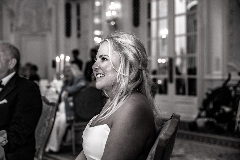 The bride watches speeches at her Savoy wedding in London