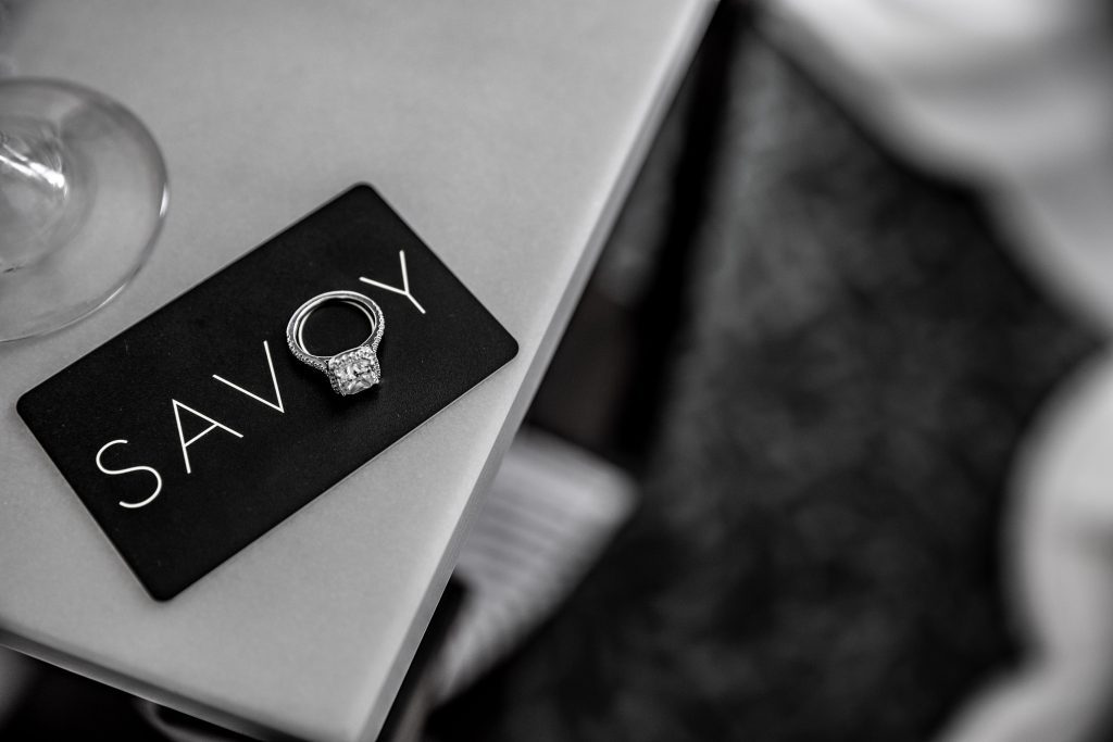 A wedding ring sits on a Savoy key card
