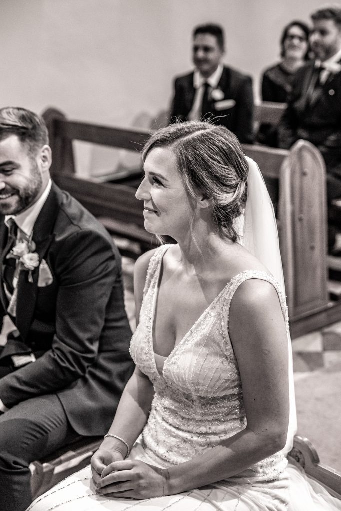 a bride smiles as she says her vows