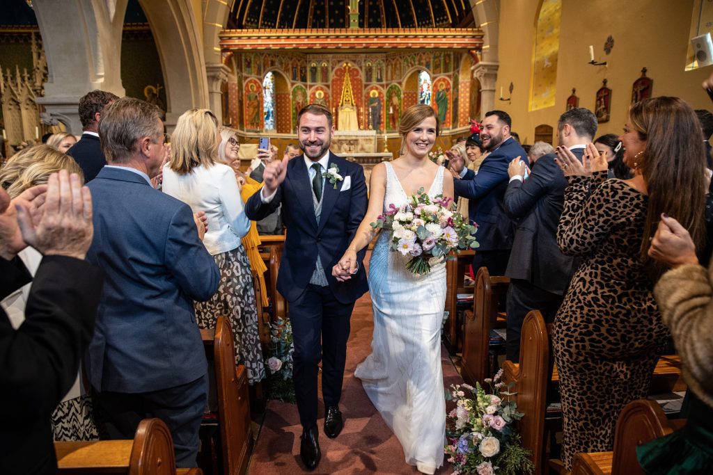 Bride and groom walk down the aisle after getting married