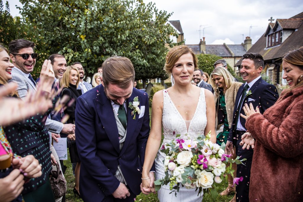 bride and groom in a confetti stream outside church