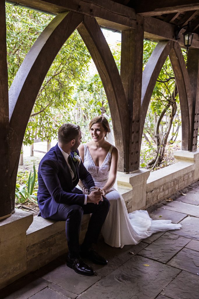 bride and groom pose outside Hertford church