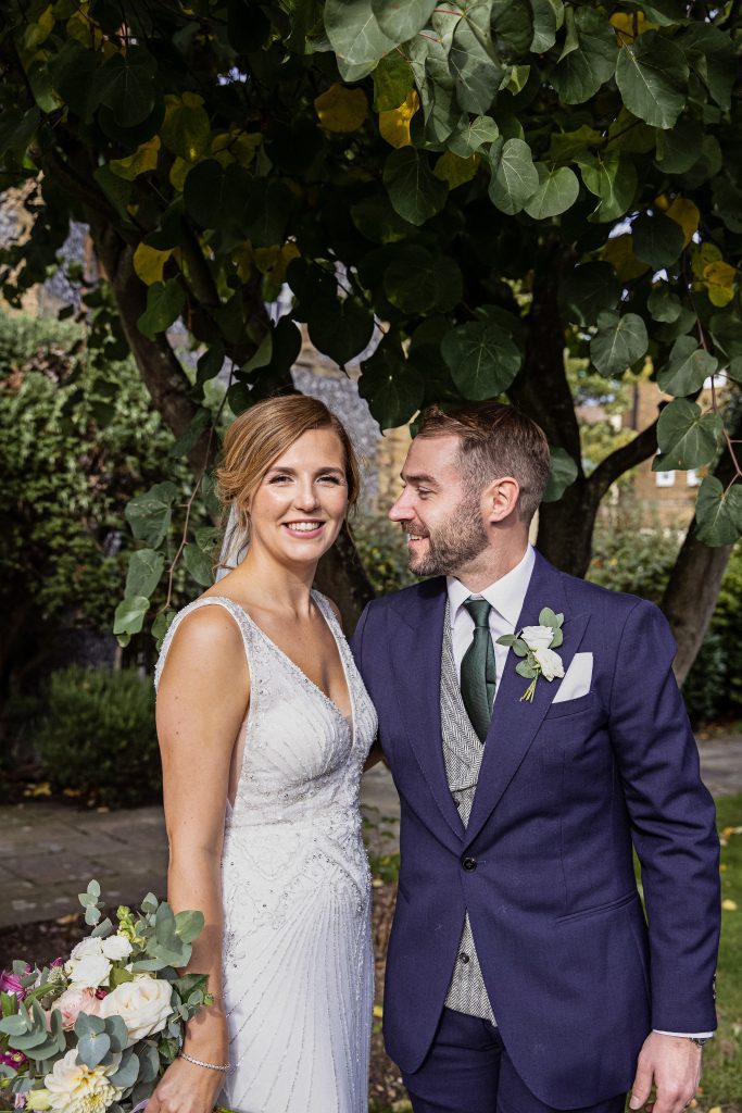 Bride and groom pose outside Hertford Catholic church