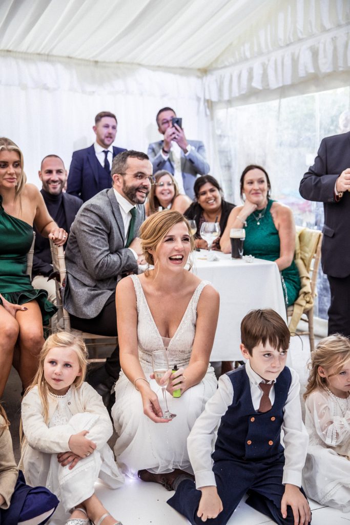 a bride and her wedding guests listen to speeches