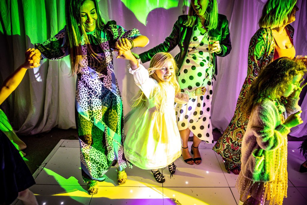 a little girl dances at a wedding