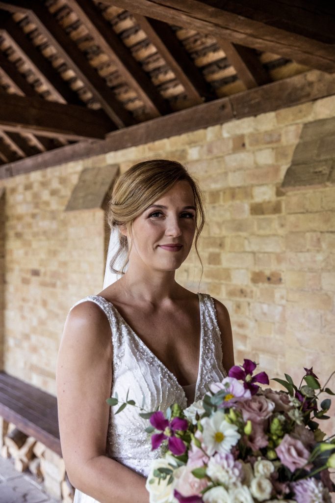 a bride smiles as she is about to walk down the aisle in Hertford