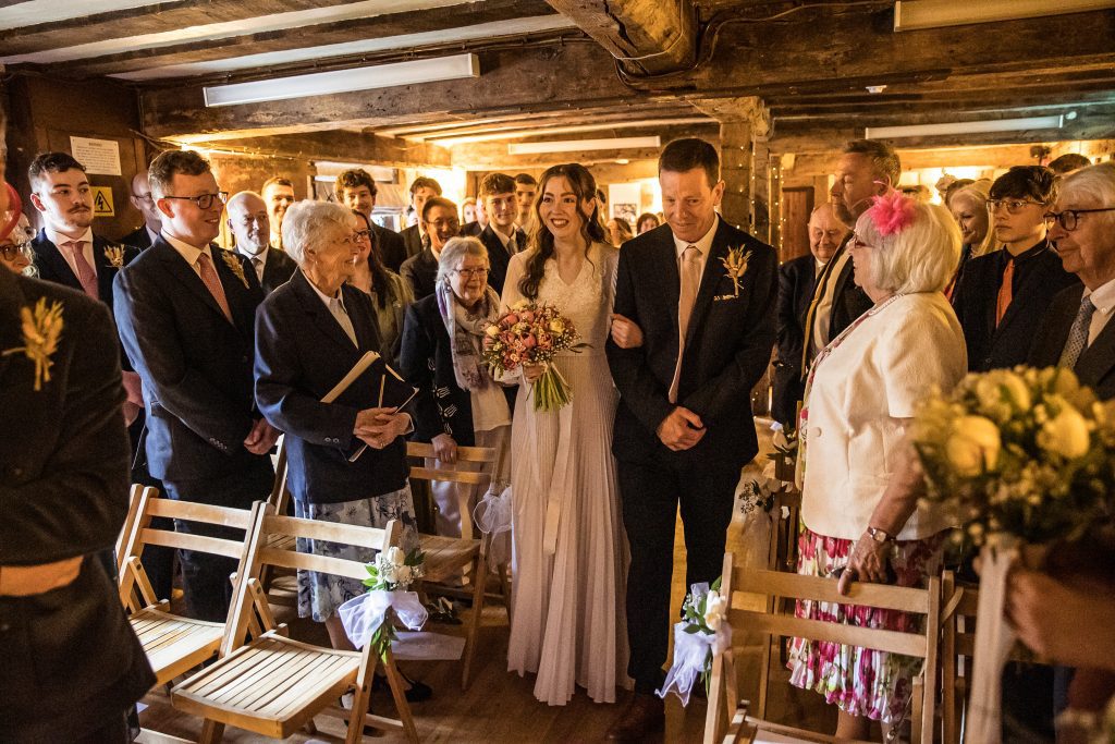 the bride and her father walk down the aisle at The Barley Townhouse in Royston