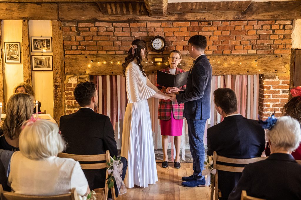 a bride and groom hold hands at the alter at their wedding in The Barley Townhouse
