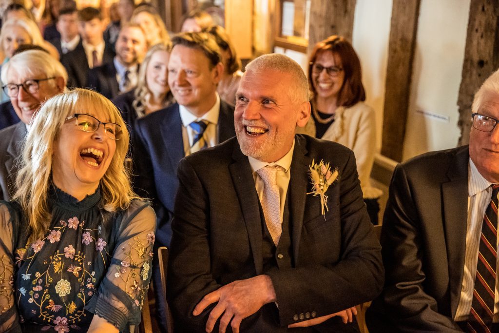 guests laugh at the wedding ceremony at The Barley Townhouse in Royston