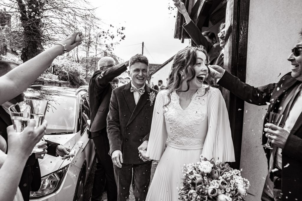 guests throw confetti outside The Barley Townhouse in Royston