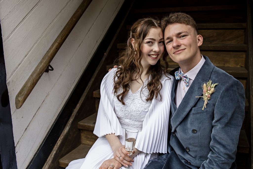 a bride and groom at their hertfordshire wedding venue sitting on the steps, their heads touching