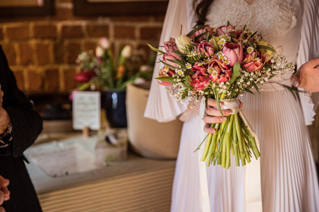 a bride holds her bouquet at her wedding ceremony at The Barley Townhouse in Royston