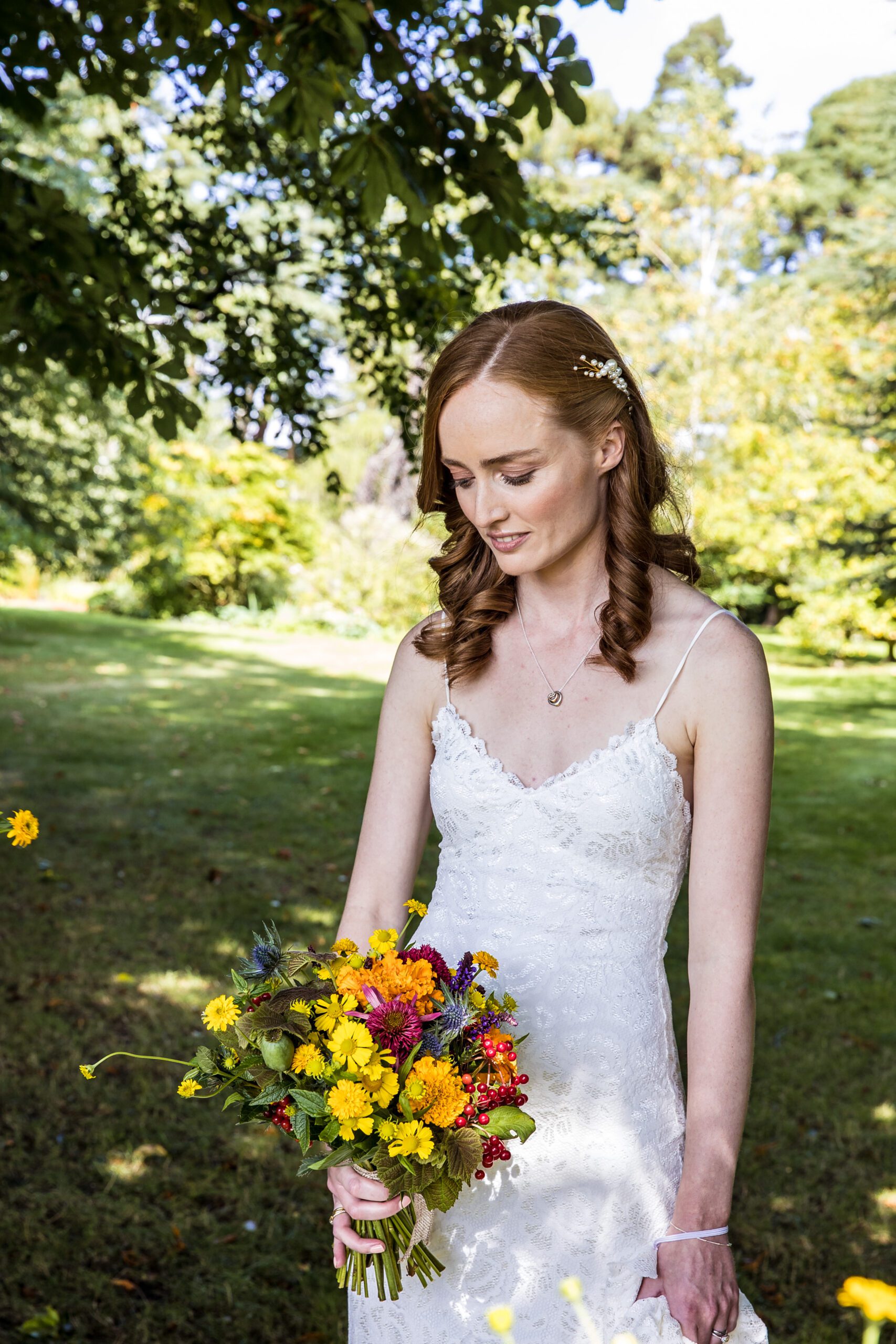 a bride looks down at her bouquet just before her wedding in hertfordshire