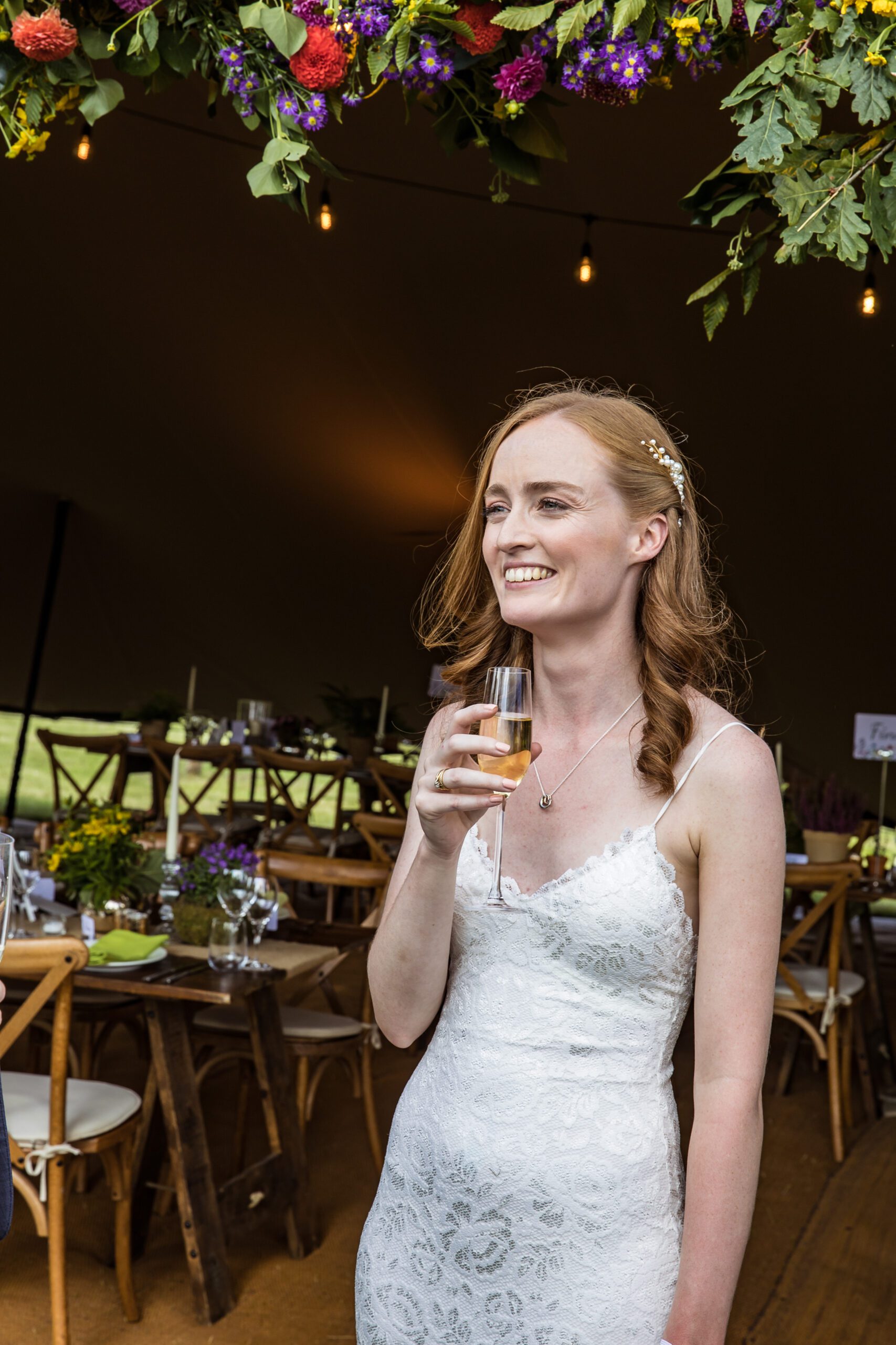 a redhead bride at her garden wedding holding a glass of champagne