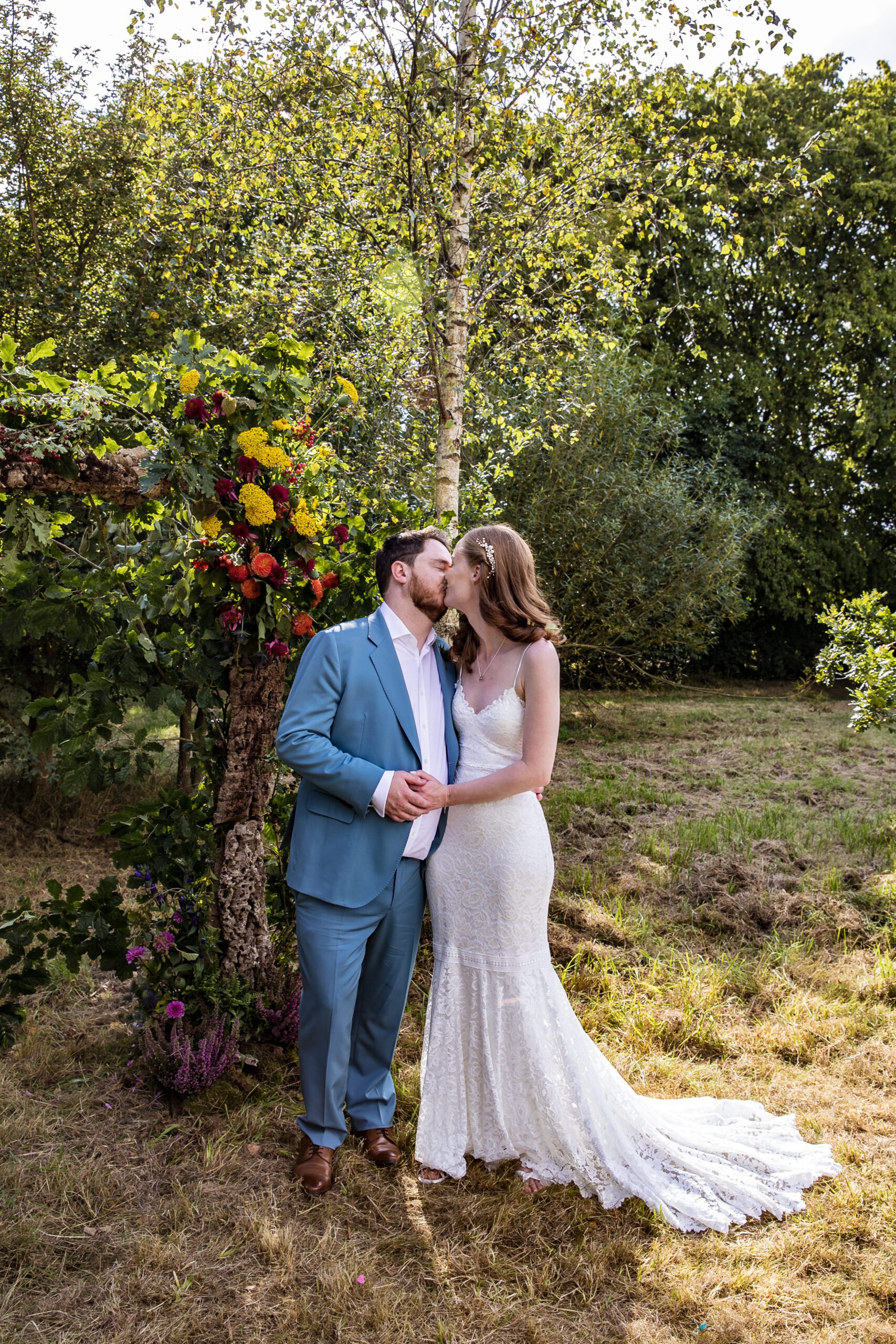 a bride and groom kiss under the alter at Hertfordshire summer wedding