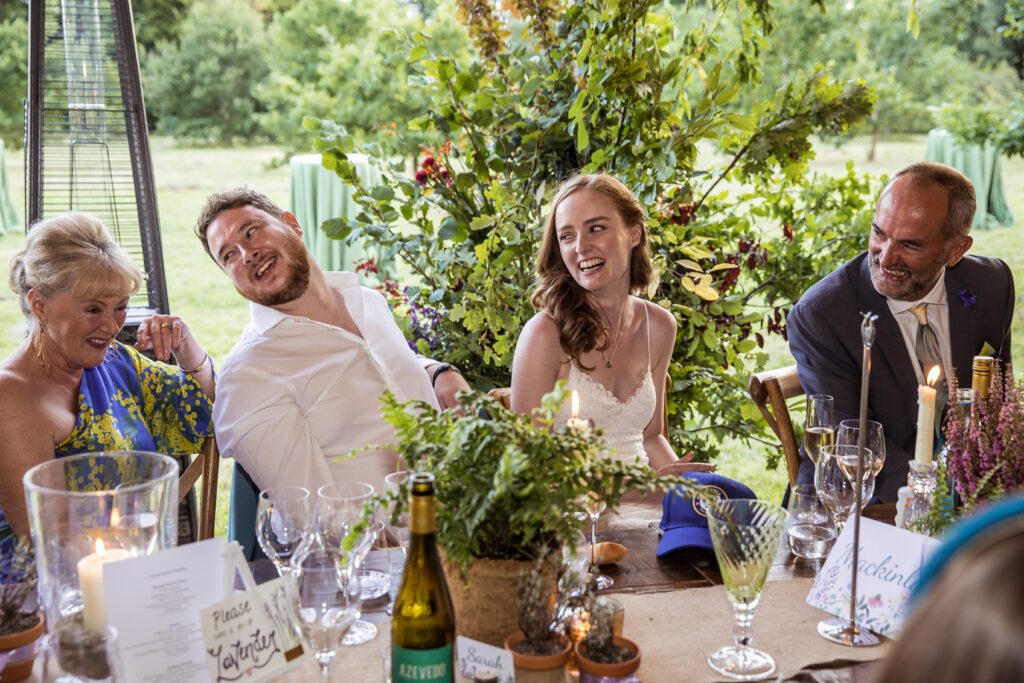 the bride and groom laugh during speeches