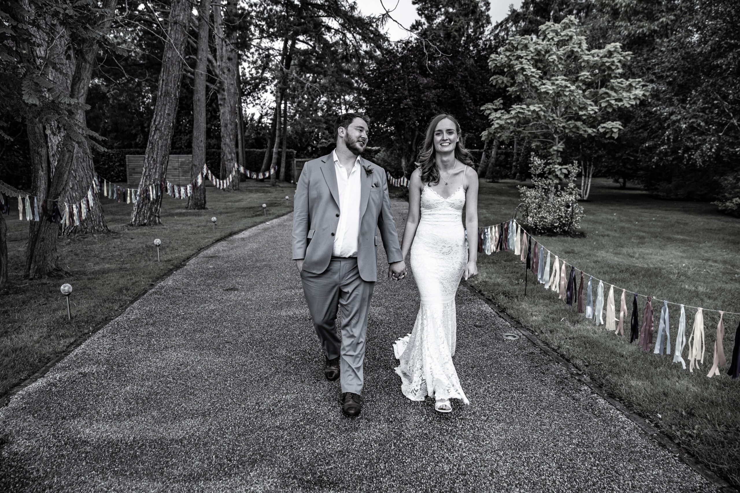 bride and groom walk down the road in hertfordshire