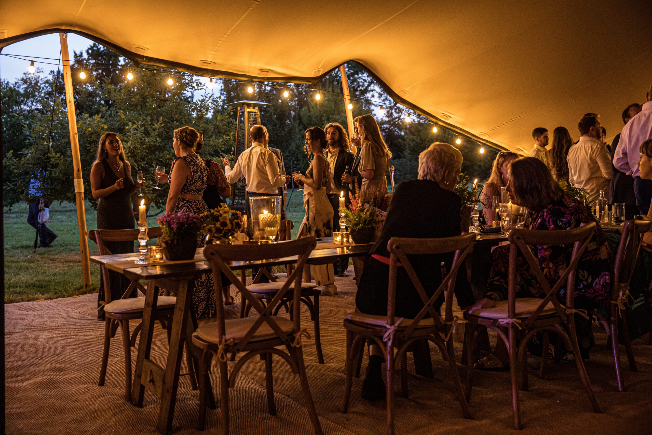 the guests mingle at hertfordshire garden wedding at dusk