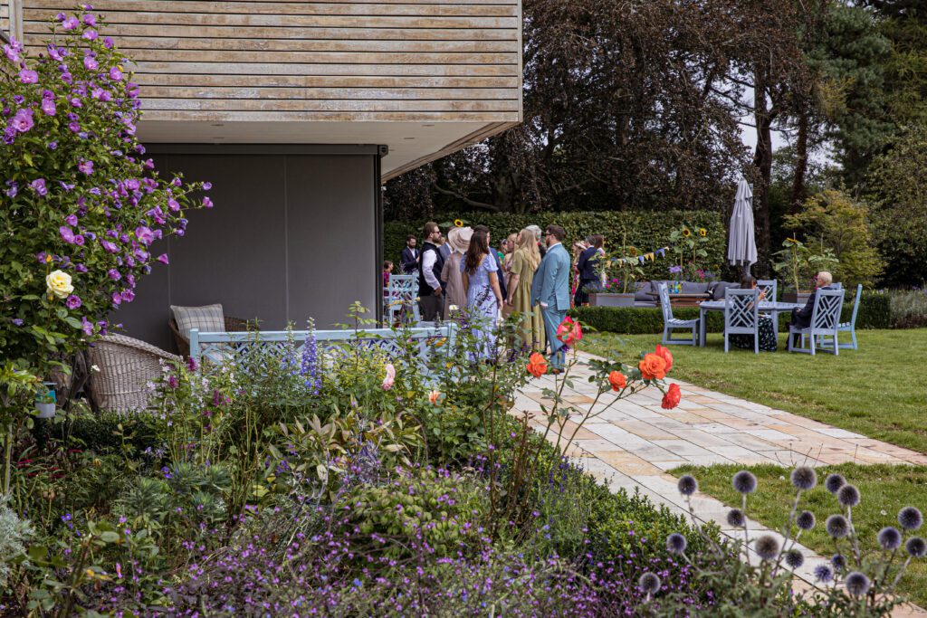 wedding guests wait for bride in the garden of a hertfordshire home