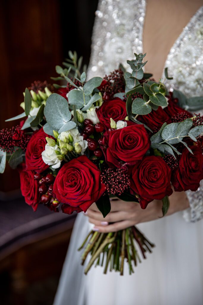 a bright elegant bouquet of red roses with green and white foliage