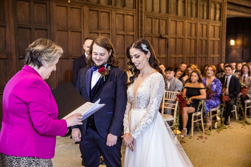 a bride and groom at their wedding service at Fanhams Hall about to recite their vows in front of friends and family at Fanhams Hall