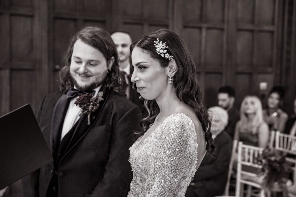 a bride and groom at their wedding service at Fanhams Hall about to recite their vows in front of friends and family at Fanhams Hall