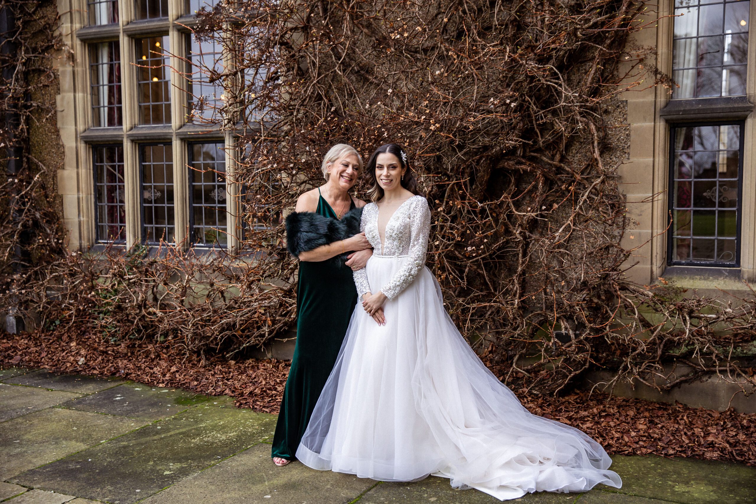 a mother and her daughter pose in the grounds of Fanhams Hall at a christmas wedding in Hertfordshire