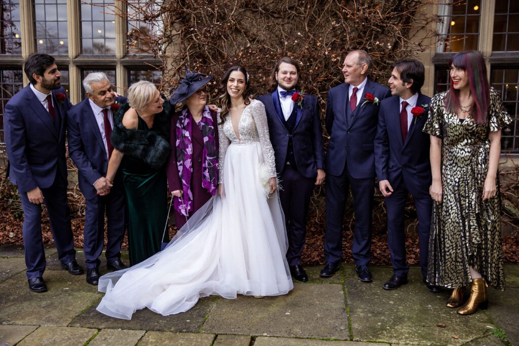 A group pose at a family wedding in the gardens of Fanhams Hall in Hertfordshire.