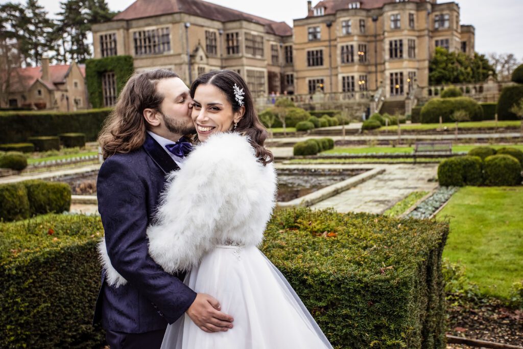 Bride and groom pose in the gardens of their weddings at Fanhams Hall in Hertfordshire