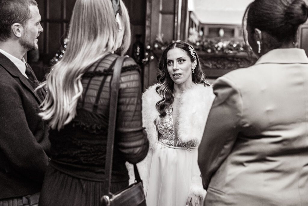 A bride talks to her guests at her wedding reception at Fanhams Hall in Hertfordshire