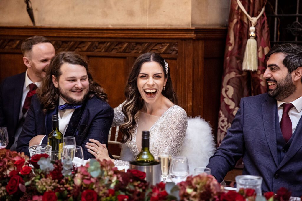 Bride laughs during her speeches at her wedding at Fanhams Hall