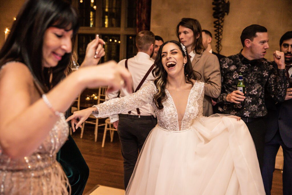 a bride dances on the dance floor at her wedding at Fanhams Hall in Hertfordshire