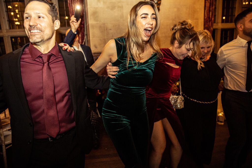 Guests dance a greek wedding dance at Fanhams Hall in Hertfordshire