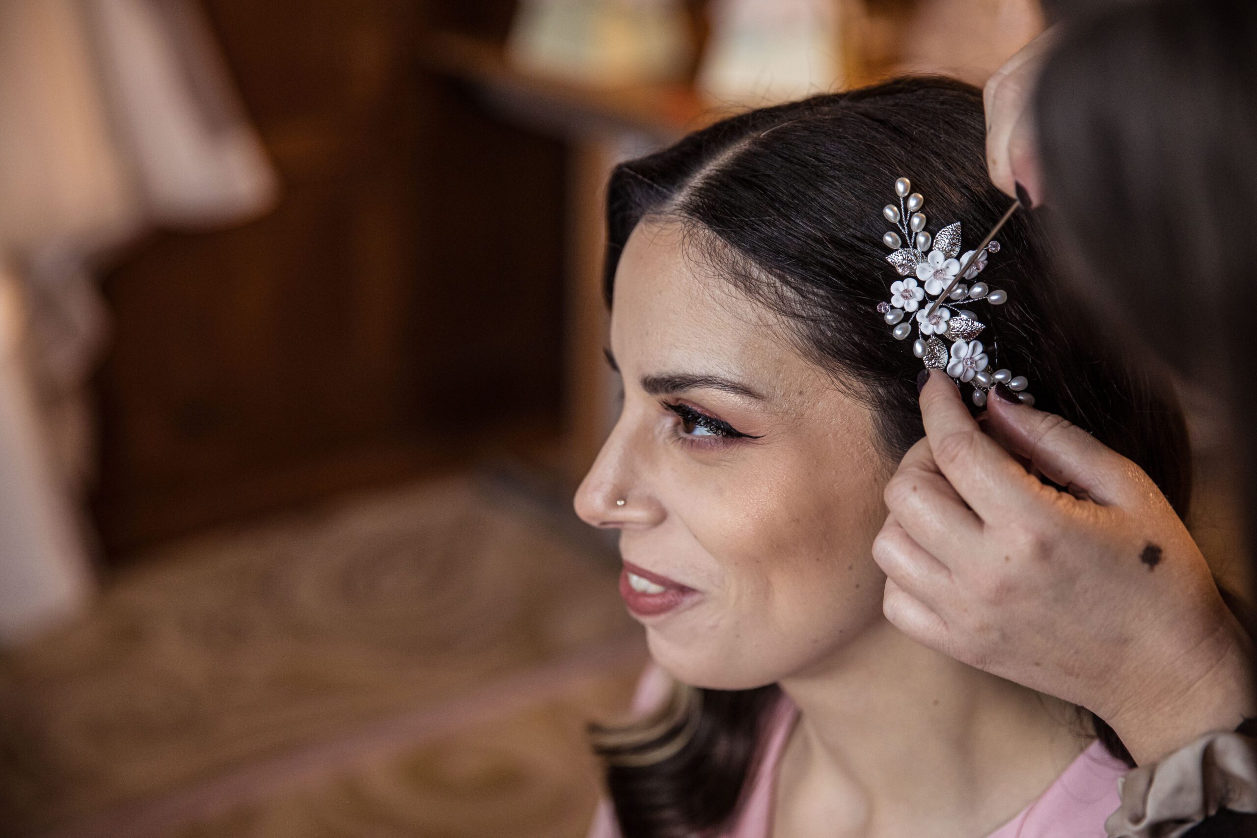 A hair ornament is placed in the brides hair in the rooms of Fanhams Hall
