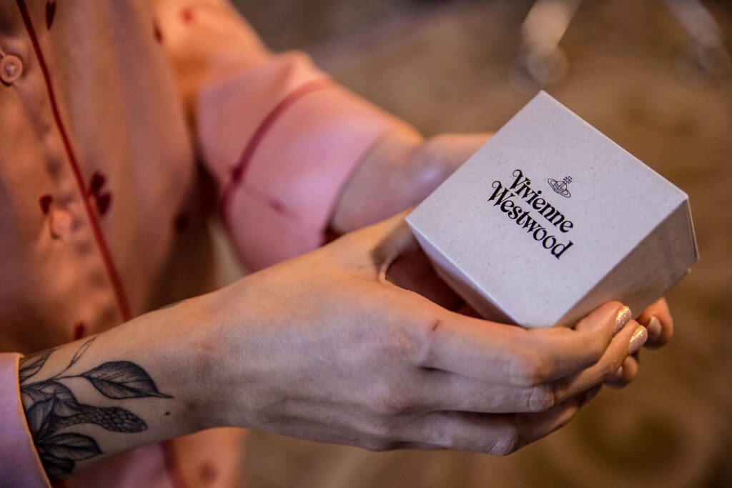 a bride hold out her Vivienne Westwood earrings as she is about to wear them