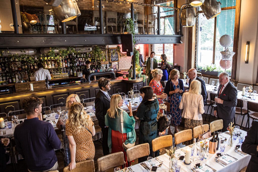 wedding Guests assemble for drinks on the ground level of Balfour St Barts pub in London